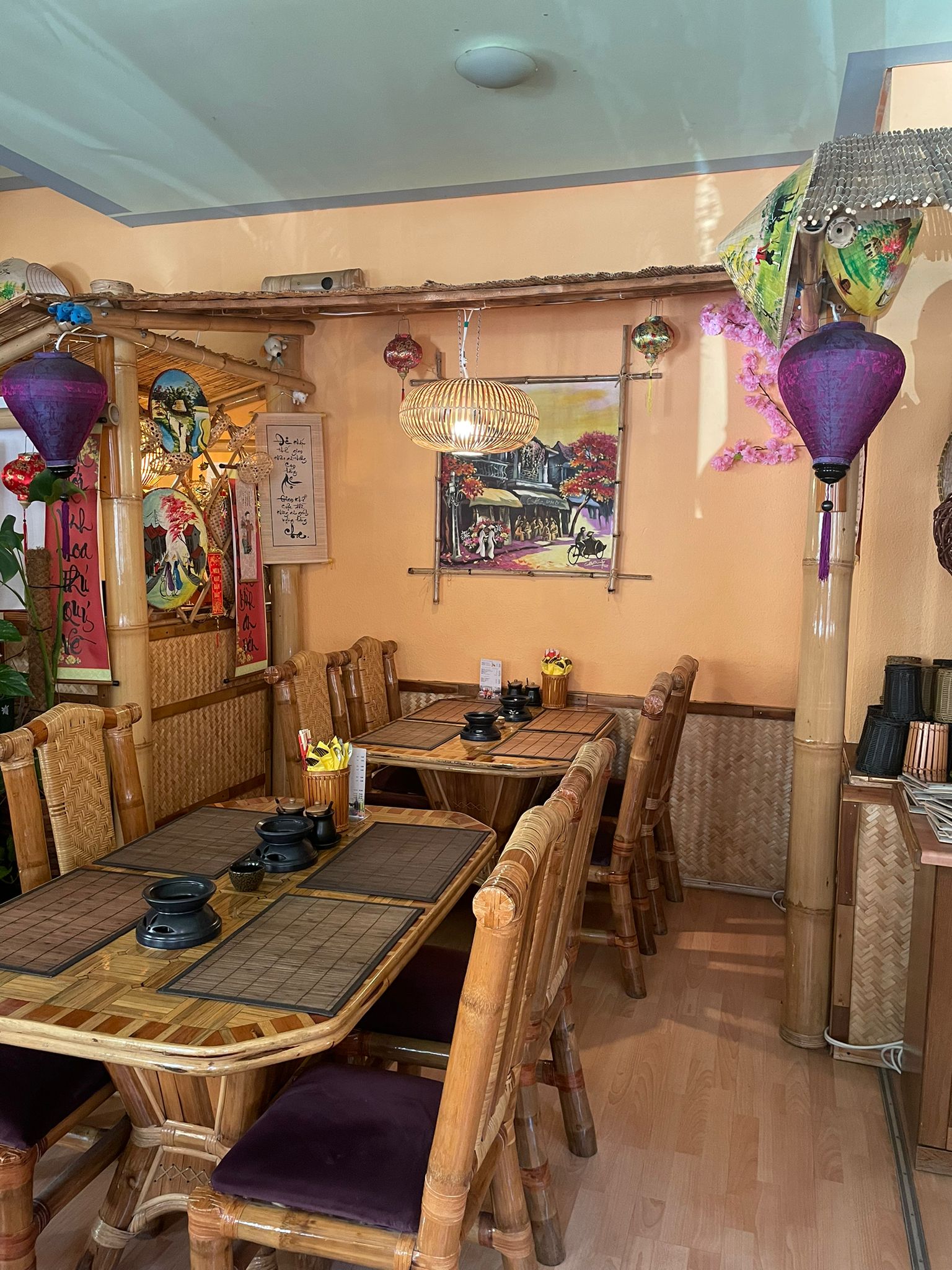 Ein gemütliches, asiatisch eingerichtetes Restaurant mit Bambusmöbeln und bunten Lampions.